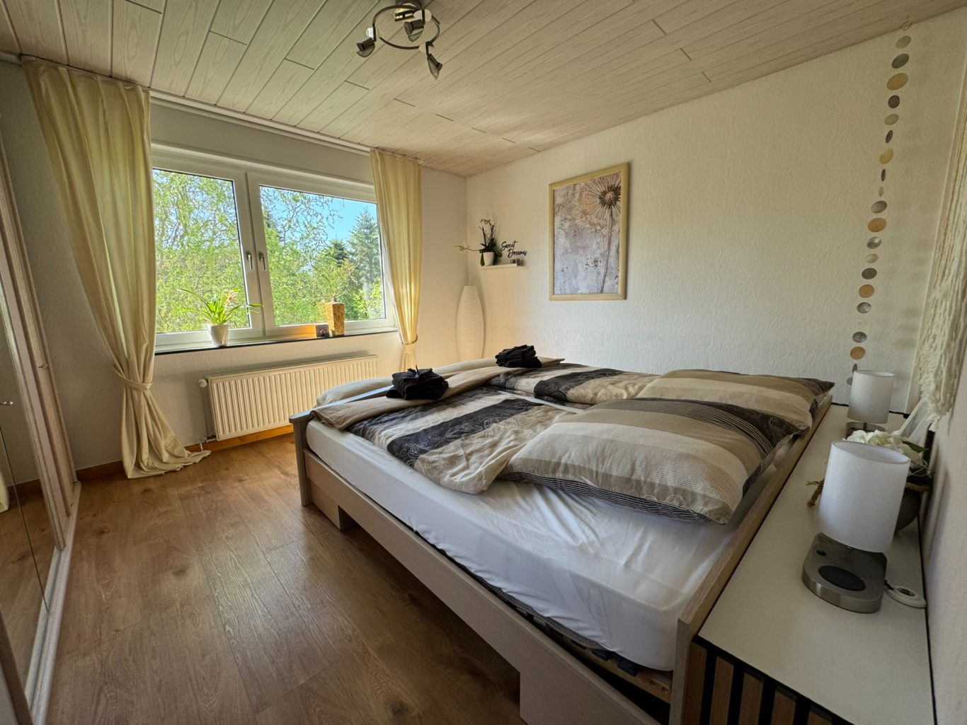 Schlafzimmer Helles Schlafzimmer mit einem Doppelbett, Fenster und Blick ins Grüne.
