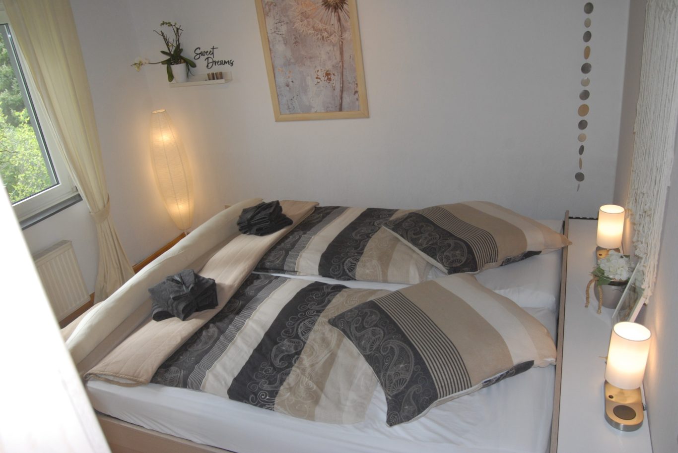 2x2 Meter Bett Gepflegtes Schlafzimmer mit zwei Betten, dekoriert in neutralen Farben und sanfter Beleuchtung.