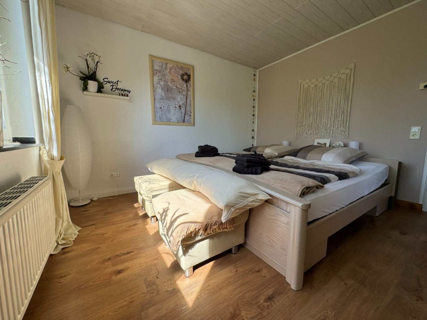 2m Seitenschläferrolle Helles Schlafzimmer mit Doppelbett, Kissen und dekorativen Elementen.